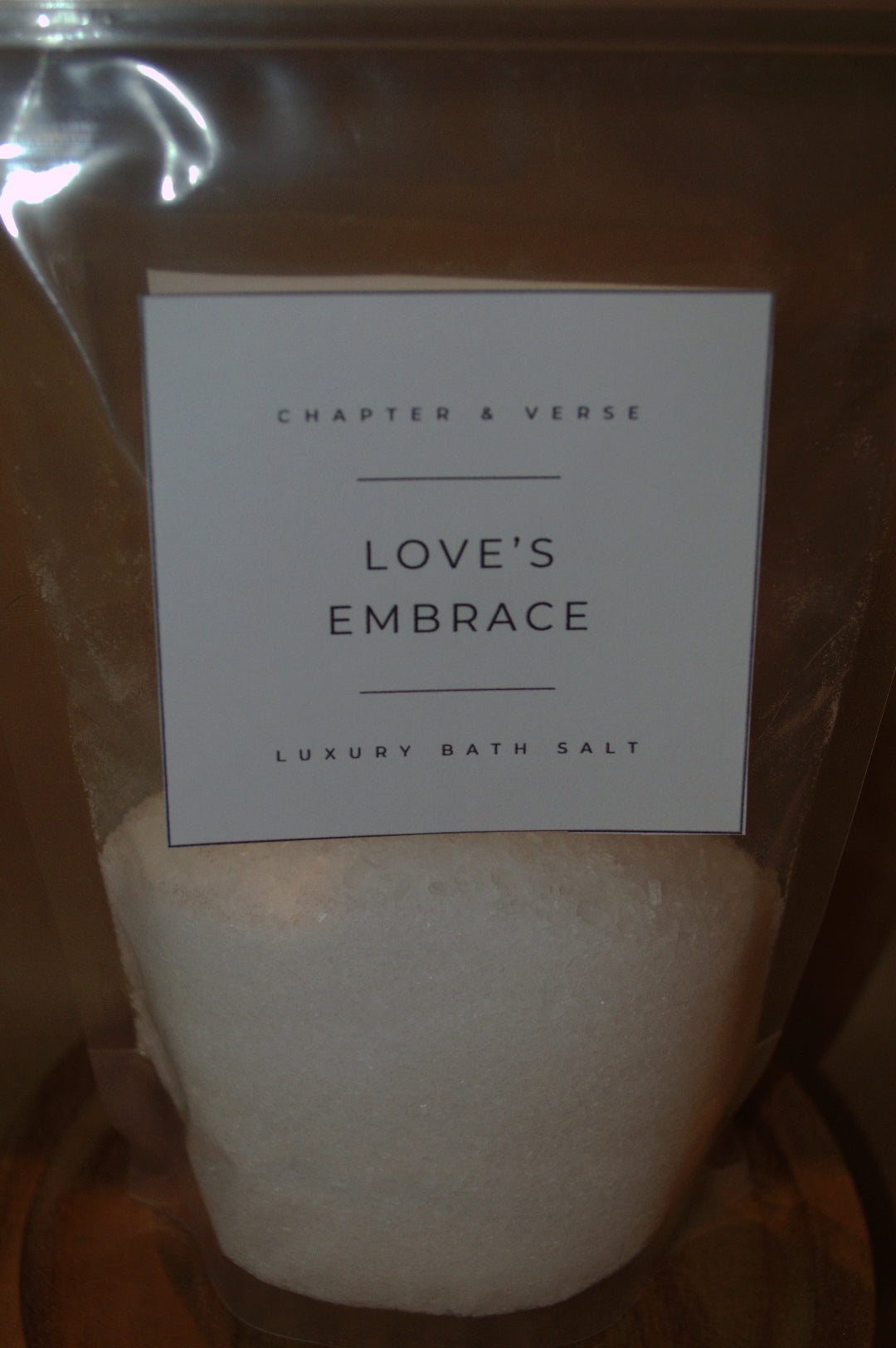 Pack of bath salts with a label reading 'Love's Embrace' from Chapter & Verse.